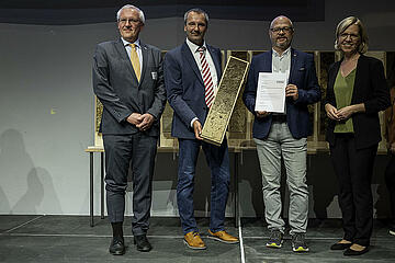 Umweltgemeinderat Gerald Hicke und Bauhofchef-Thomas Leeb bei der Preisverleihung des "ERDREICH-Preis" mit Ministerin Leonore Gewessler. 