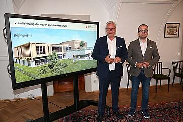 Bürgermeister Thomas Steiner mit dem 1. Vizebürgermeister Istvan Deli vor der Visualisierung der neuen Volksschule. 