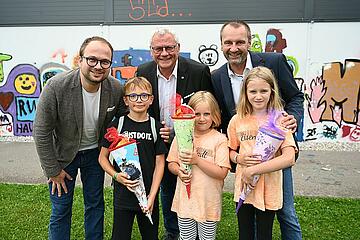 Bürgermeister Thomas Steiner, Vizebürgermeister Istvan Deli (l.) und Gerald Hicke (r.), Obmann des Ausschusses für Jugend, Schule und Sport freuen sich mit den Kids über den  Schulstartbonus. 