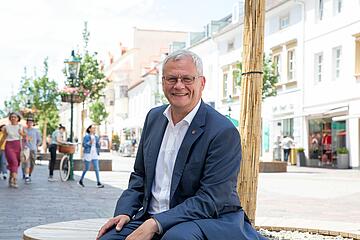 Bürgermeister Steiner auf einem der Sitzbänke auf der Fußgängerzone. 