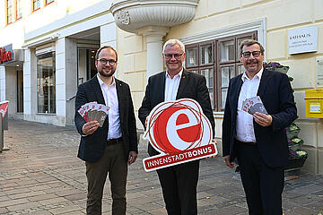 Bürgermeister Thomas Steiner, 1. Vizebürgermeister Istvan Deli und 2. Vizebürgermeister Otto Kropf mit Gutscheinen und Logo vor dem Rathaus